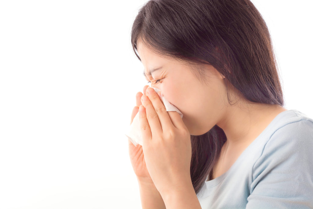 一个亚洲女孩因鼻窦炎而用纸巾擤鼻涕，为博客《我需要做鼻窦手术吗？